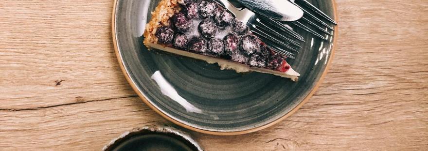 photo of a cup of coffee and a piece of blueberry pie